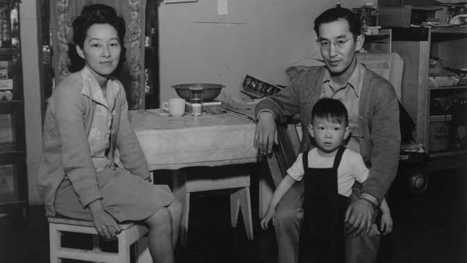 Henry and Ayako Tsurutani seated at the kitchen table in their Manzanar barracks with their son, Bruce, on his 3rd birthday | Ansel Adams