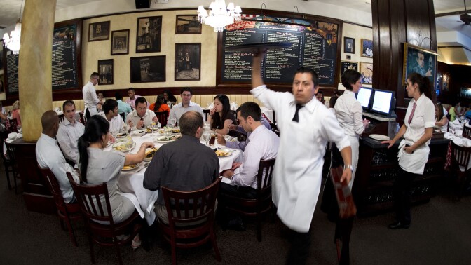 A waiter at Tony's Restaurant, part of the Casablanca Hotel, in Times Square in New York. | DON EMMERT/AFP/Getty Images