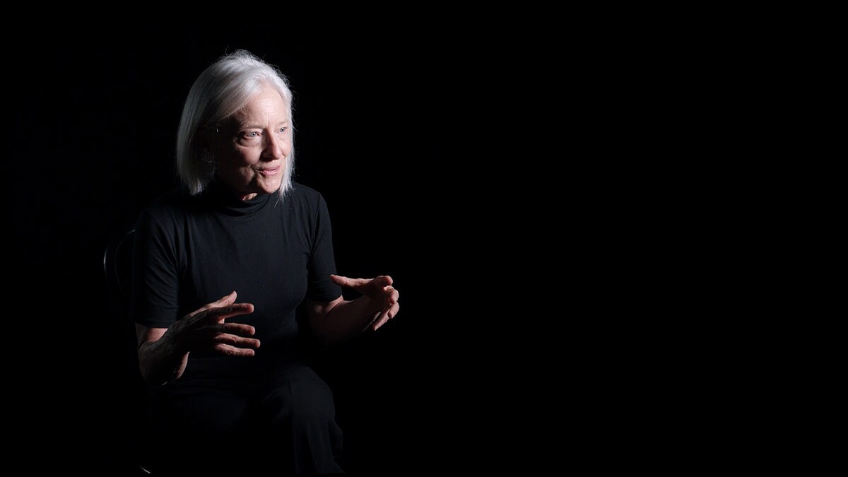Ann Carlson sits in front of a black background. | Courtesy of UCLA