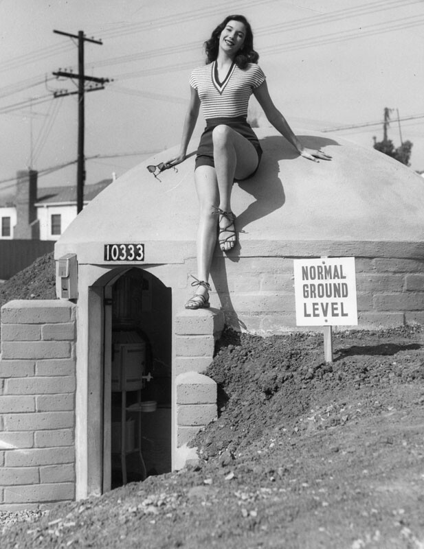 Mary Lou Miner, in summer sportswear, poses on top of a concrete-block bomb shelter. Apr. 7, 1951. | LAPL