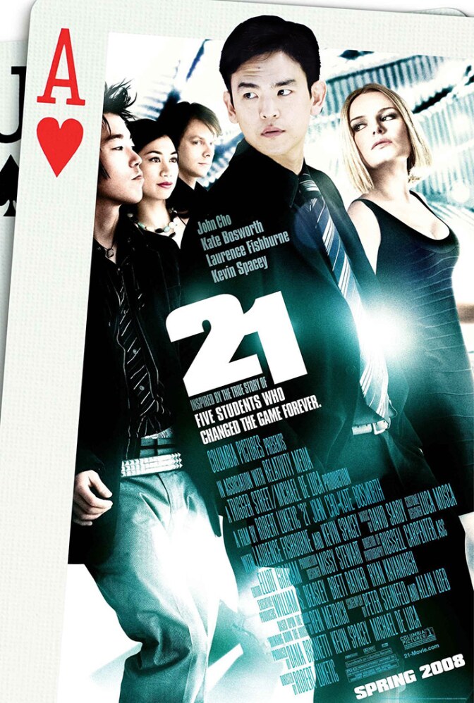 An Asian American man in black stands in front of a blond woman and several others.