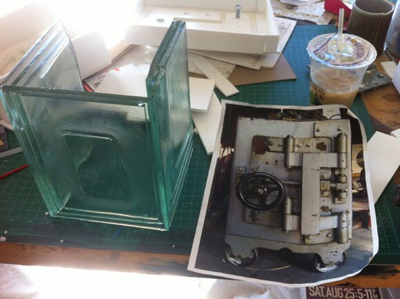 Test pieces for Liz Glynn's glass copy of a Diebold safe in her studio. The original safe is pictured in the photocopy at right | Photo: Sharon Mizota.