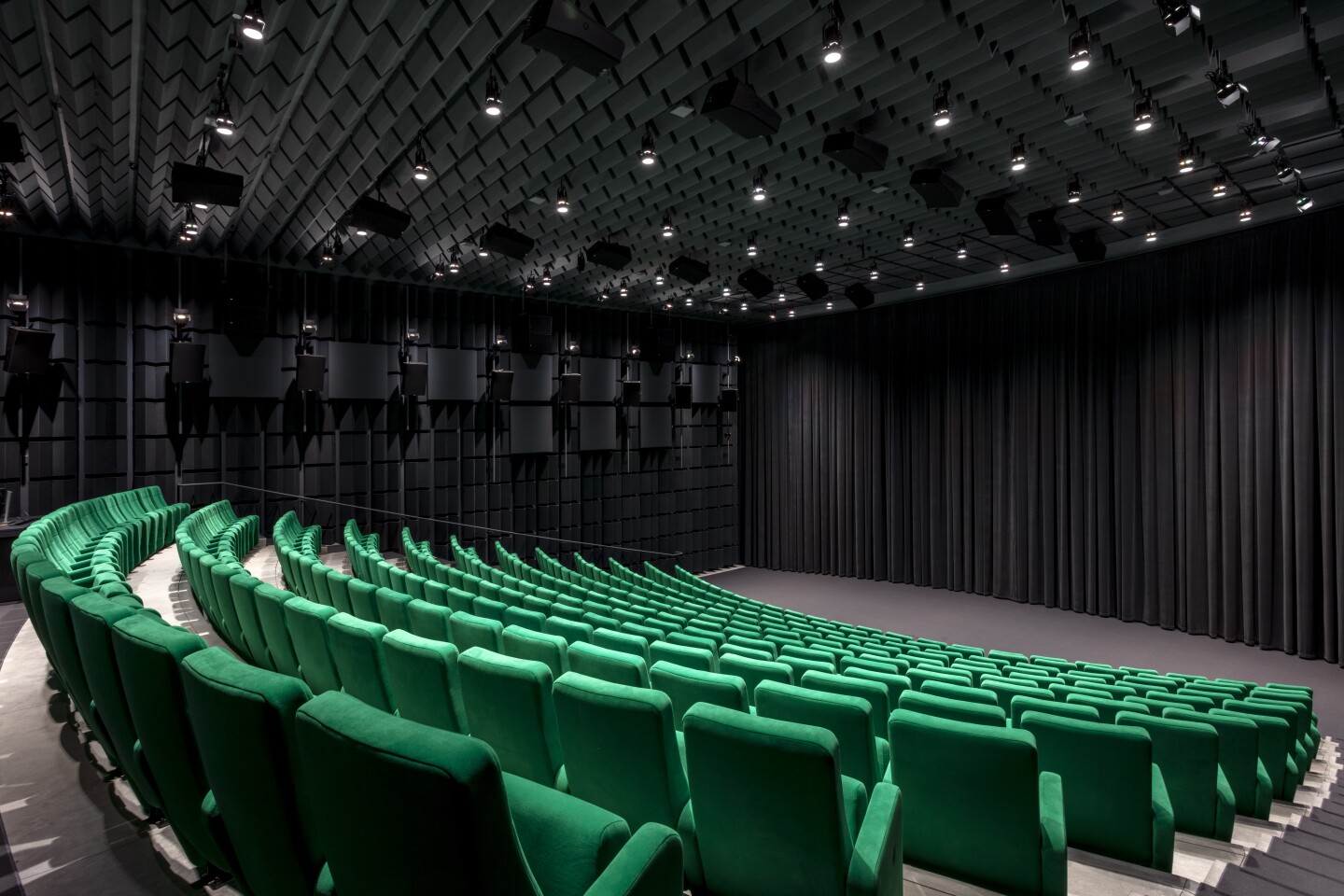 The Ted Mann Theater in the Academy Museum of Motion Pictures features bright green seats and black curtains.