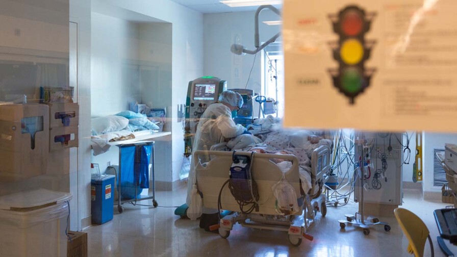 Nurse Yvonne Yaory checks on a coronavirus patient who is connected to a ventilator. | Heidi de Marco/California Healthline