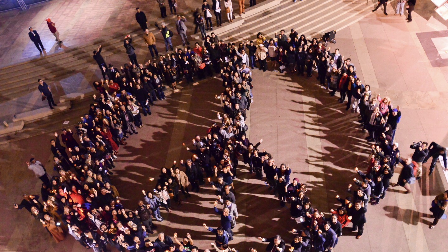 A Vigilant Love rally gathers in the shape of a peace sign in Little Tokyo, Los Angeles.