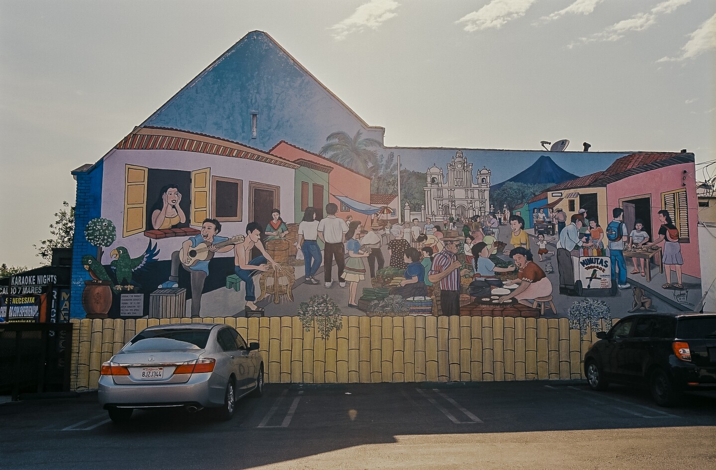 A mural on the back wall of Salvadoran Restaurant La Nueva Flor Blanca features a scene of a Salvadoran town.