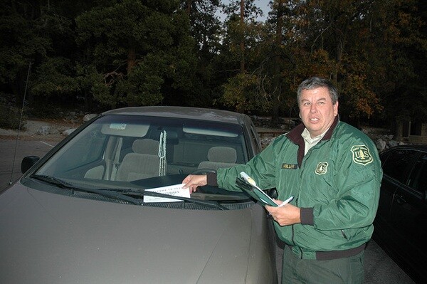 John Miller issues a ticket for parking in the San Bernardino National Forest without a day or adventure pass | Photo: John Heil/USFS