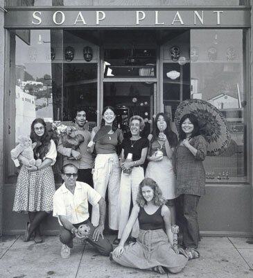 A black and white photo of Barbara Shire, center, with friends and family in front of the original Soap Plant storefront on Sunset Blvd in the 1970s.