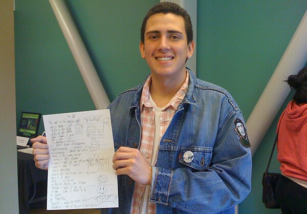 Mauro Zepeda holds up his poem, "The Pad"