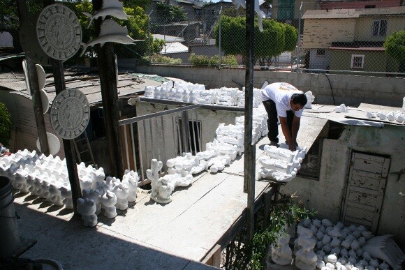 Oscar checking on the progress of <em>alcancias</em> he has set to dry on the roof of his workshop. | Photo: Misael Diaz.