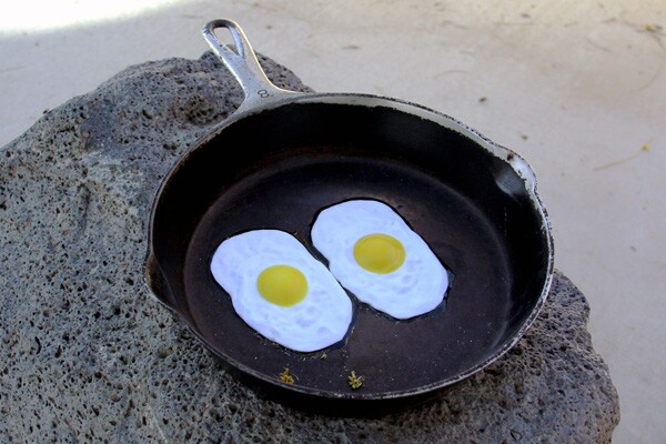Sculpture of a pan with eggs frying, at the base of the thermometer