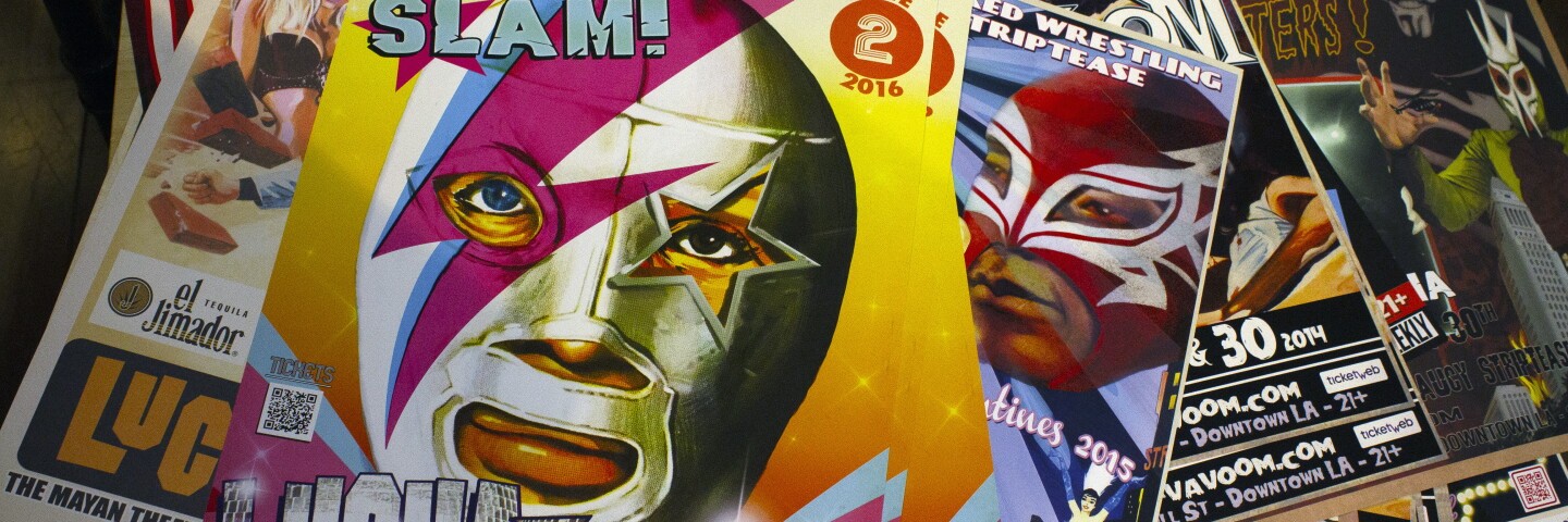 Lucha libre posters are stacked on top of each other. 