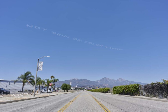 "NOT SKIN OR COLOR #XMAP" written in in the sky, contributed by Bruce Yonemoto over the Pomona Assembly Center | Hiroshi Clark, In Plain Sight
