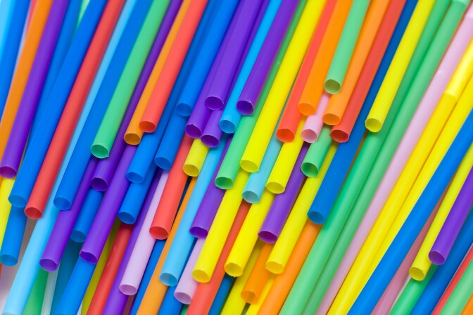 Multi-colored plastic straws thrown on top of each other