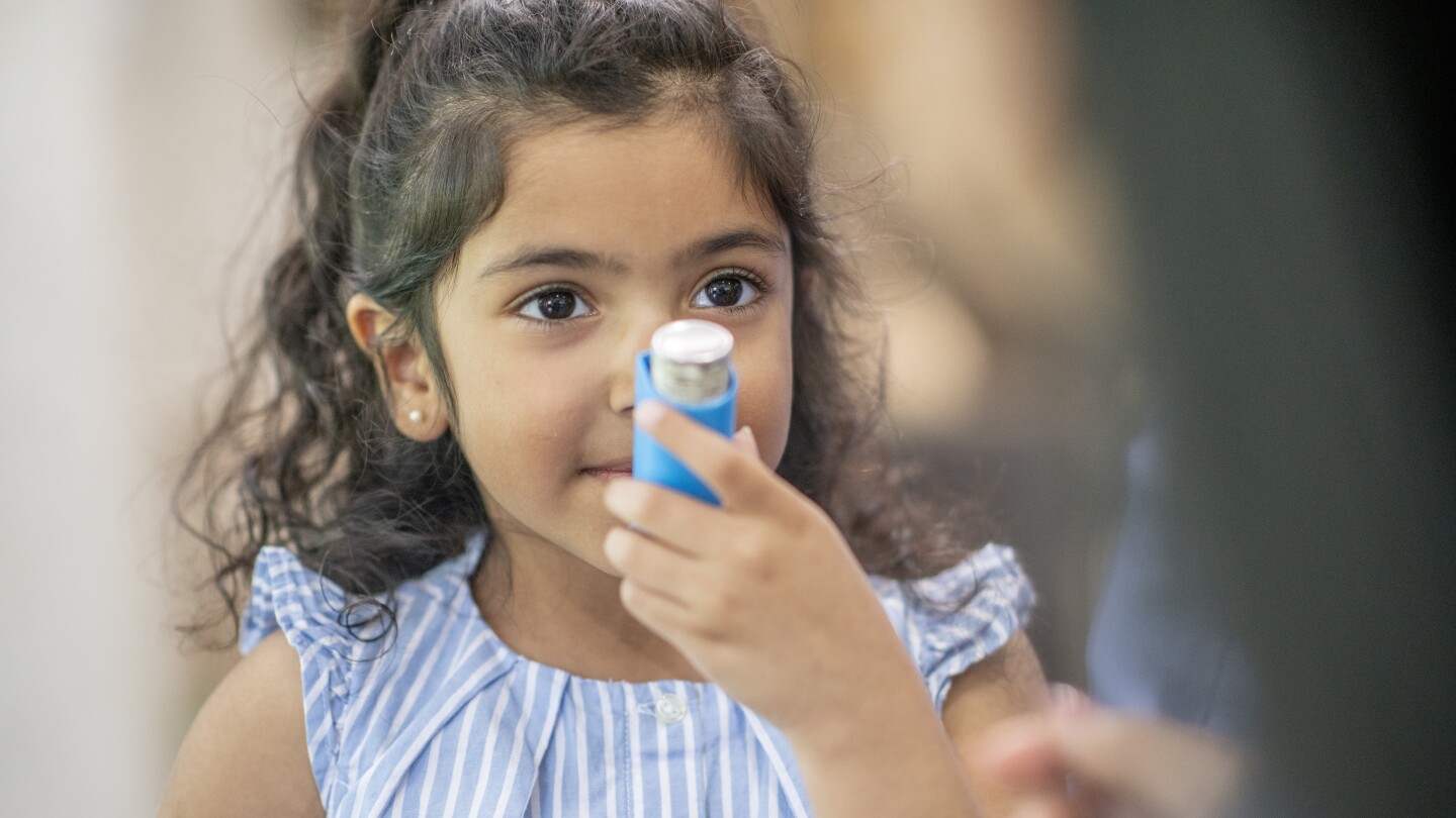 Young girl using an asthma inhaler