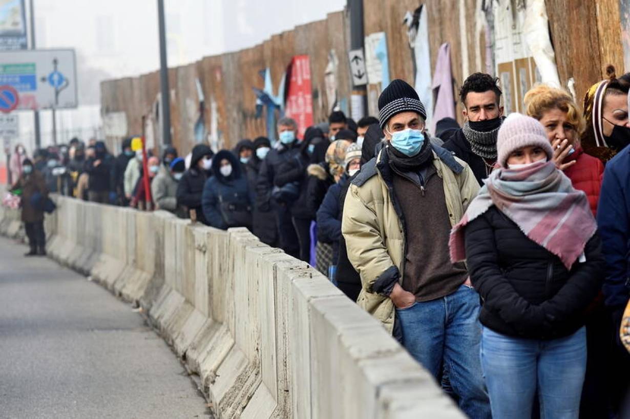 People queue for free food as Italians struggle to cope in a tough economic climate amid the coronavirus disease (COVID-19) pandemic in Milan, Italy December 14, 2020. | REUTERS/Flavio Lo Scalzo