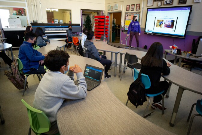 Students sit distanced from one another in a classroom.
