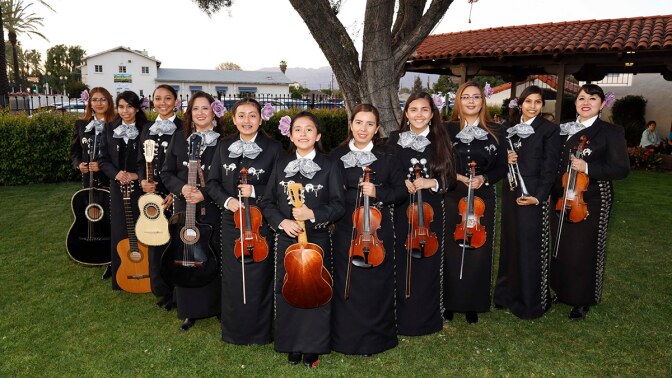Mariachi Conservatory All-Female Ensemble preparing to perform at the pre-concert outdoor community stage, including Angelica Mata (far left) and sister America (third from right) with their mom, Esperanza Juarez (far right). | Eddie Sakaki