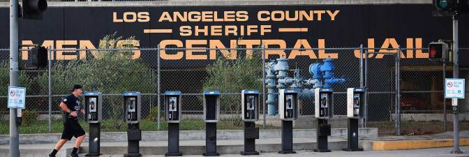 A man jogs past a row of telephone booths in front of the Los Angeles County Men's Central Jail on May 11, 2020 in Los Angeles.