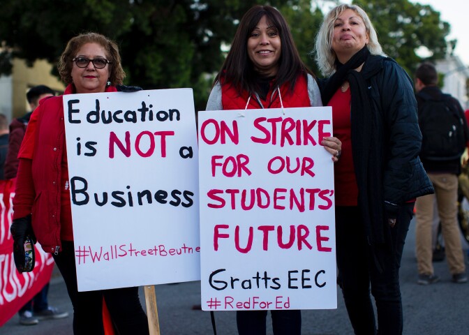 Women holding teacher strike signs in Los Angeles | LaTerrian McIntosh / Unsplash