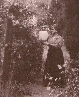 Olive Percival hangs lanterns in her garden | Photo from The Children's Garden Book