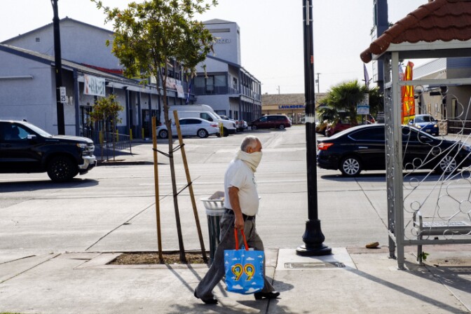 A man wears a scarf around his face as a makeshift face mask in Huntington Park. | Chava Sanchez/LAist