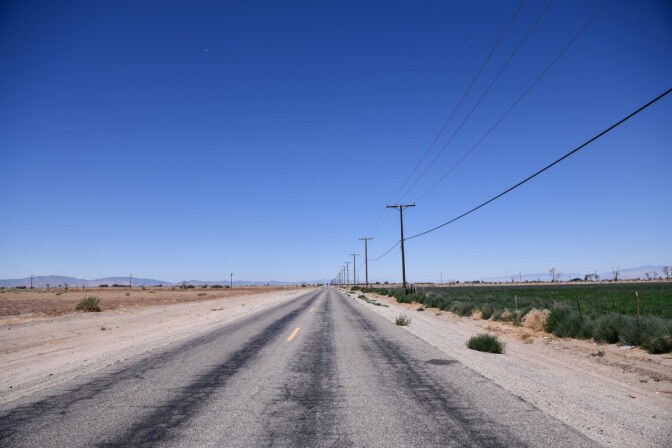 A field fallowed due to drought conditions in Lancaster is across a road from an alfalfa field.