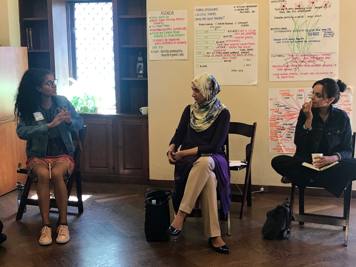 Three women sit together in discussion