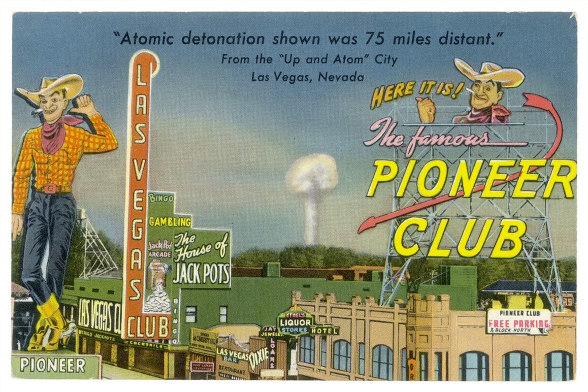 A vintage postcard that says "Atomic detonation shows was 75 miles distant." An image of a town's main street is visible with the words "Here it is! The famous Pioneer Club."