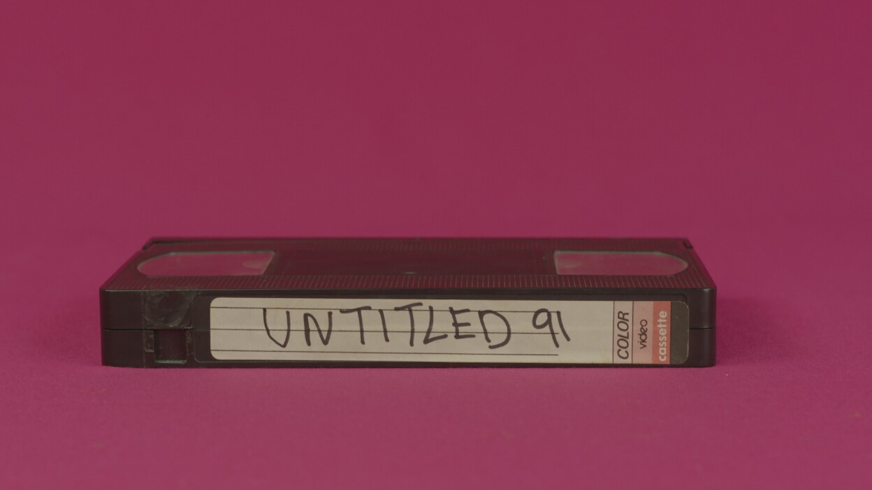 Hector Gachan music video still: a VHS tape on a fuschia background. Tape reads "Untitled 91," which is the name of the song.