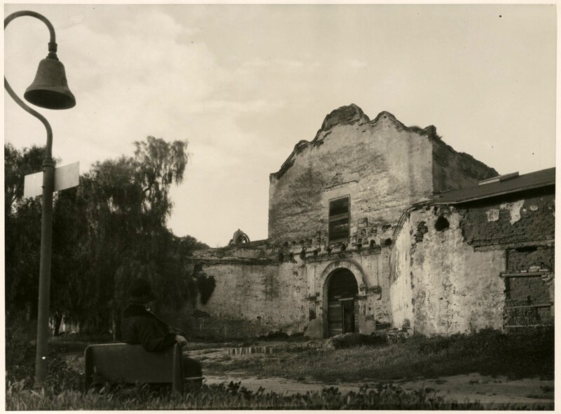 An El Camino Real bell stands outside Mission San Diego in 1930