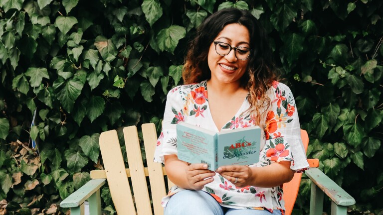 Author Maggie Carranza poses with her book "ABCs of El Salvador."