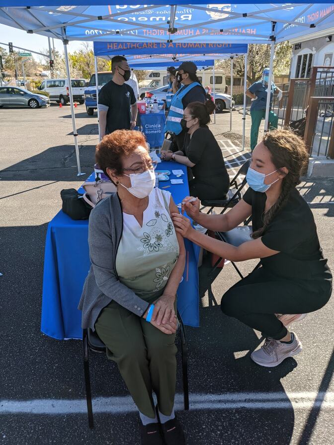 Woman gets vaccinated at a Clinica Romero tent.