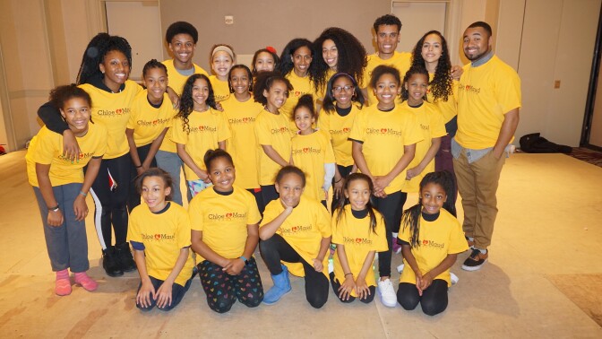Students and faculty of Chloe and Maud Foundation wearing yellow pose together for a photo.