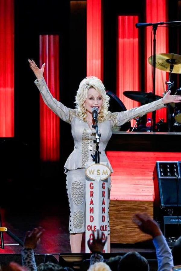 Dolly Parton outstretches her arms during a performance on stage. | From "Dolly Parton: I Will Always Love You (My Music)"