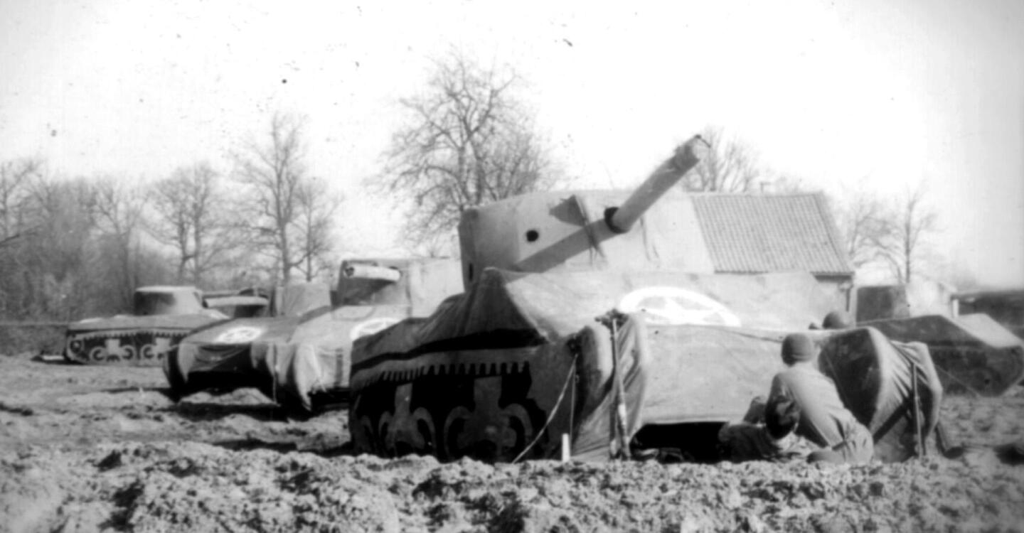 Large tanks roll through a battlefield.