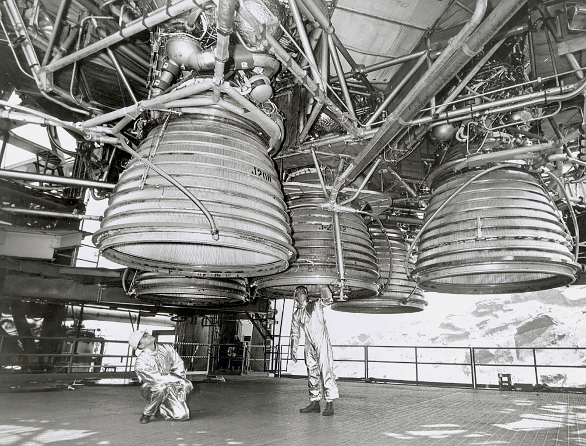 Two workers are dwarfed by five Rocketdyne J-2 engines of the Saturn V second stage (S-II) as they make final inspections prior to a static test firing by North American Rockwell’s Space Division. | Courtesy of NASA