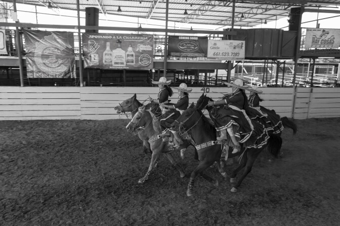 Las mujeres vestidas con charreada mexicana son caballos de montar veloces.