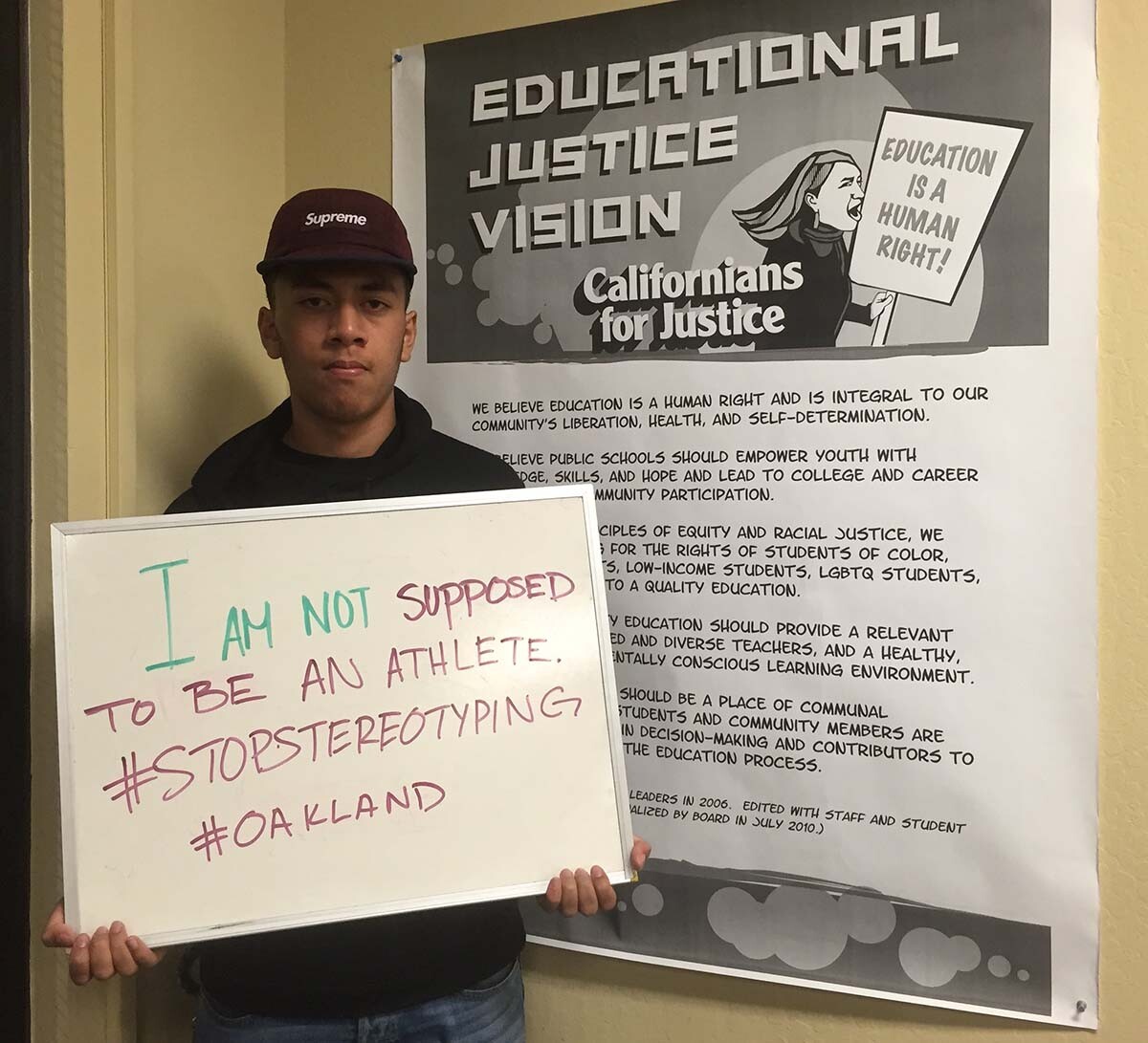 A young man hold out a sign that says "I'm not supposed to be an athlete" as part of the “Flip the Frame” campaign to challenge the damaging assumptions imposed on Black and Brown youth. | Californians for Justice