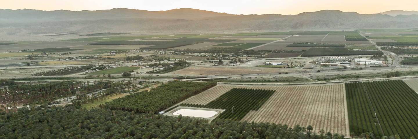Aerial view of agricultural land against Coachella Valley mountains. | Lift to Rise
