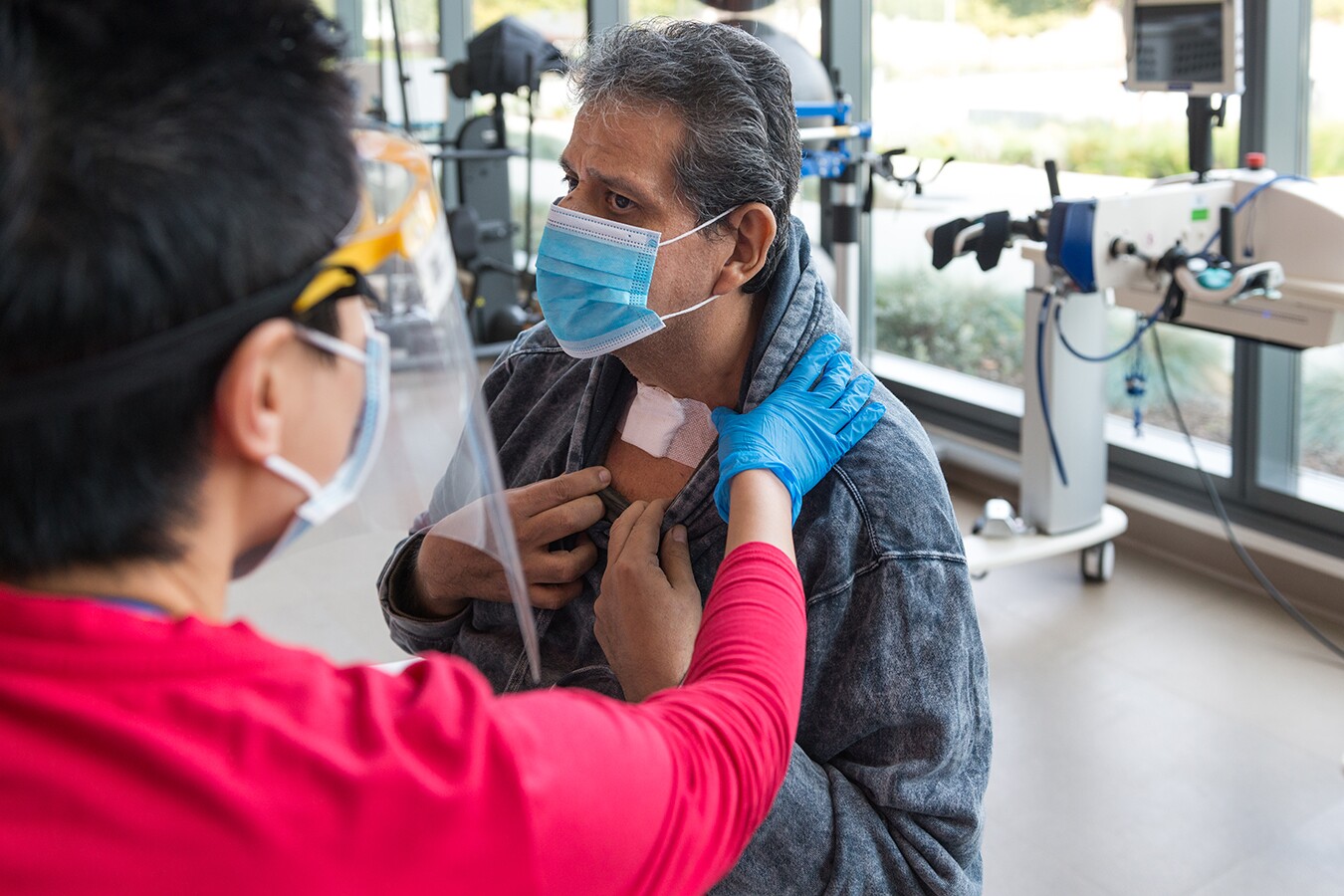 Speech pathologist Katherine Chan checks Vicente Perez Castro’s throat. He had a tracheotomy while in the hospital for COVID-19.