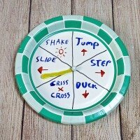 A paper plate spinner is divided and marked with instructions like step to the right, jump and duck.