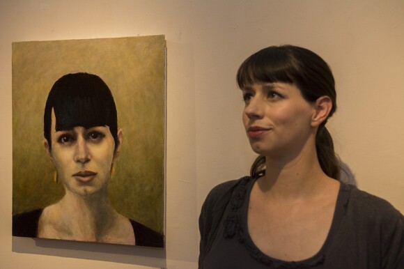 The author poses with her portrait by David Settino Scott, featured in the exhibition "Women" at the Steynberg Gallery in San Luis Obispo. | Chris Daly