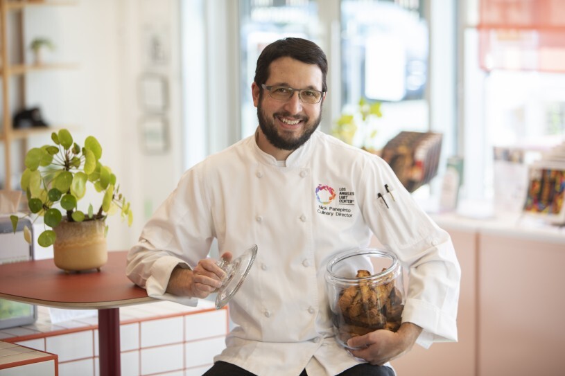 Chef Nick Panepinto, Director of Culinary Training and Operations at Liberation Coffee House, holds a jar of the cafe's biscotti, priced affordably at $2.