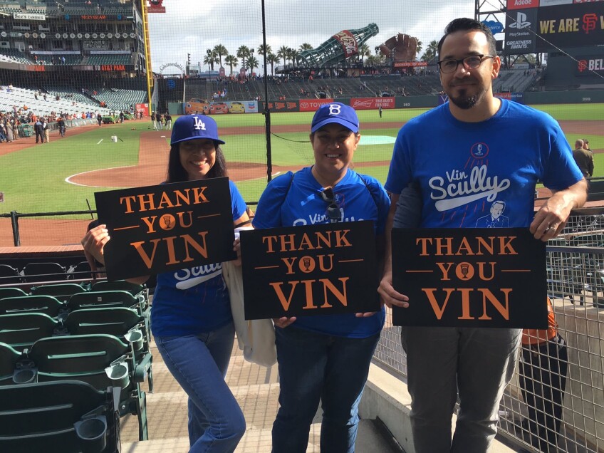 Three people holding signs that say "Thank you, Vin."
