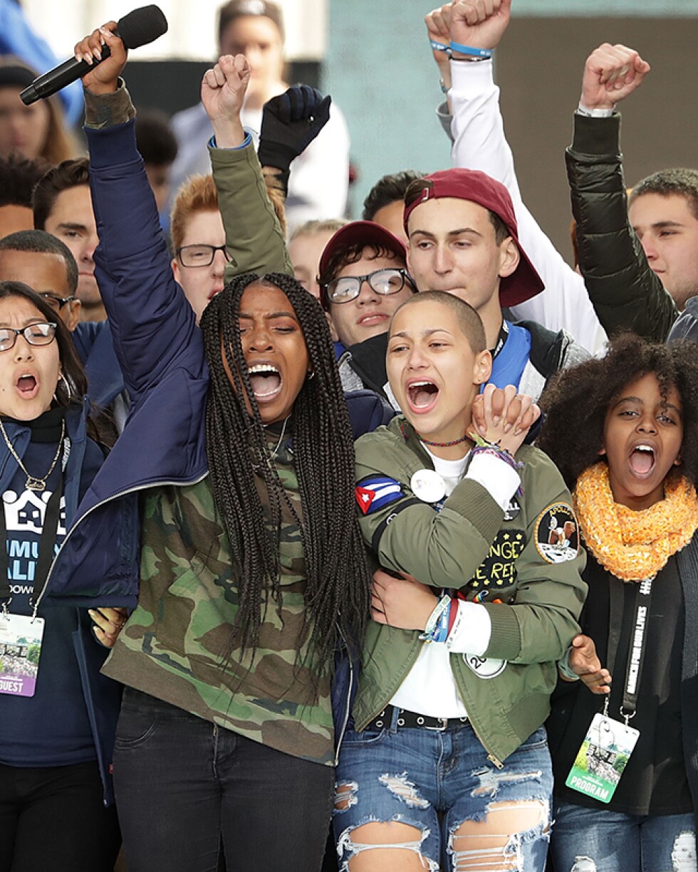 Students from Marjory Stoneman Douglas High School, including Emma Gonzalez (C), stand together on stage with other young victims of gun violence at the March for Our Lives rally on March 24, 2018 in Washington, DC. | Chip Somodevilla/Getty Images