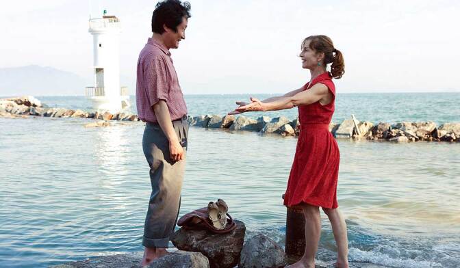 Seong-kun Mun as Munsoo and Isabelle Huppert as Anne. | Still from "In Another Country"