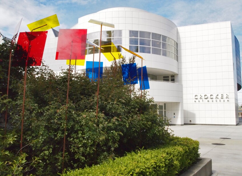 Red, yellow and blue rectangular light filters stand in a garden of greenery outside the Crocker Art Museum
