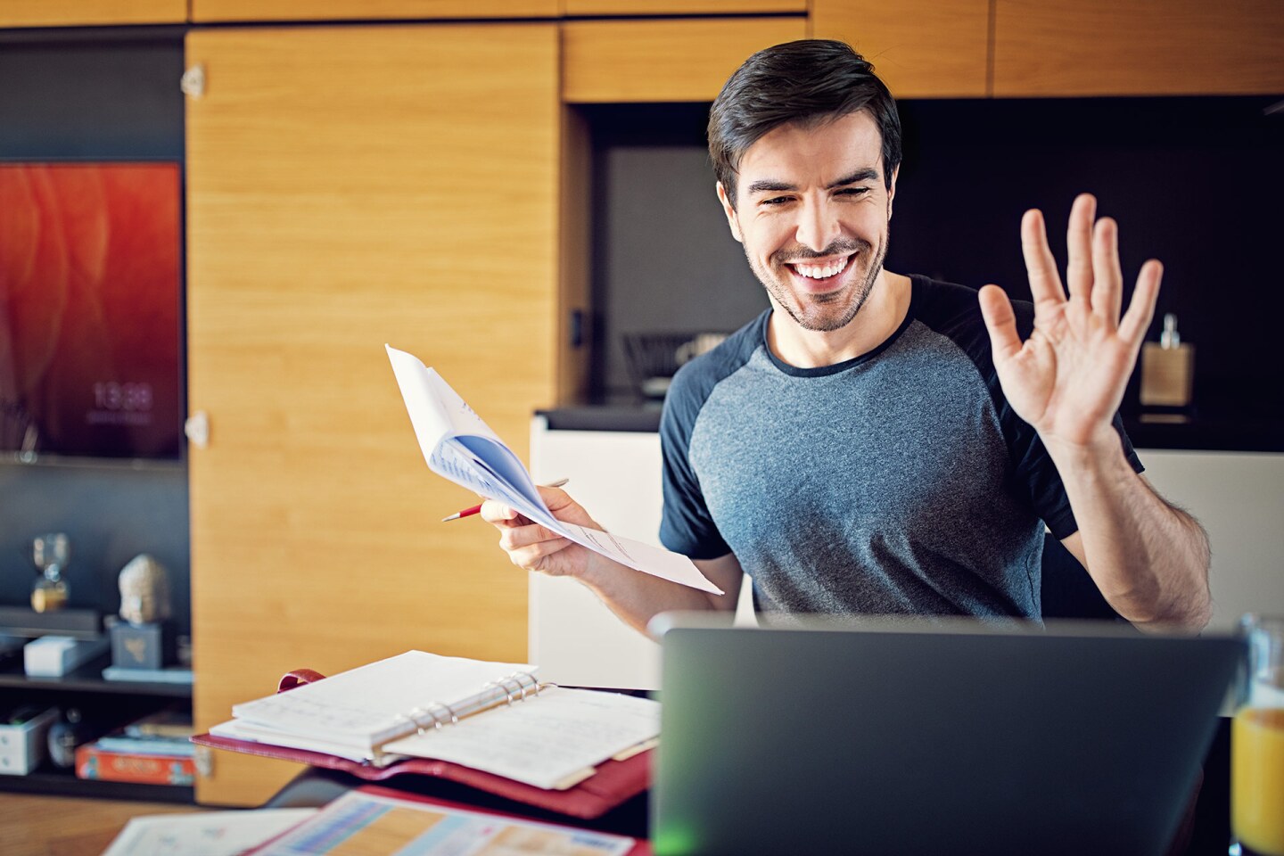A man waves to the camera as he videoconferences.
