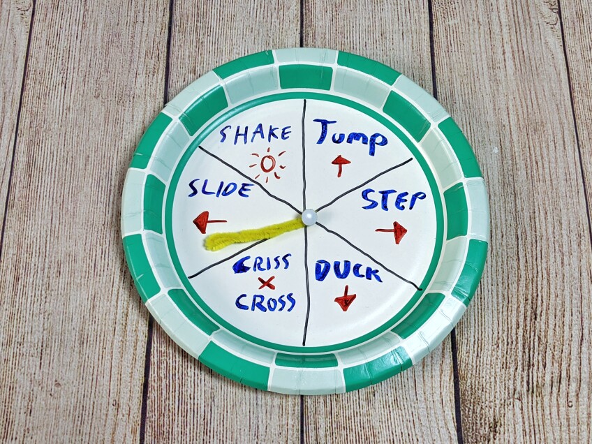 A paper plate spinner is divided and marked with instructions like step to the right, jump and duck.